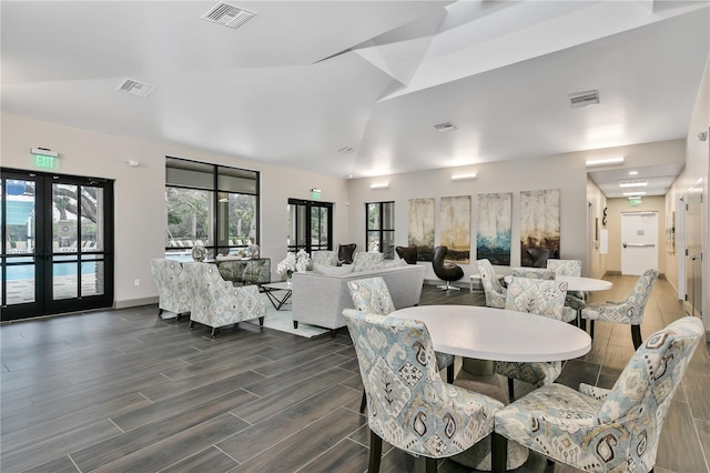 dining room with dark hardwood / wood-style floors, lofted ceiling, and french doors