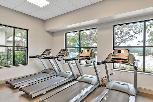 workout area featuring a paneled ceiling and a healthy amount of sunlight