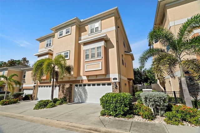 562 Rivercrest Ln, Tarpon Springs, FL 34689 - townhome / multi-family property with stucco siding, concrete driveway, a garage, stone siding, and fence