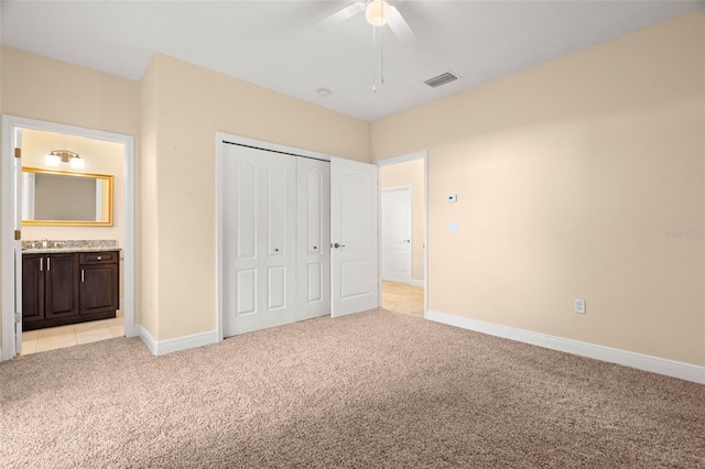 562 Rivercrest Ln, Tarpon Springs, FL 34689 - unfurnished bedroom featuring light colored carpet, baseboards, a closet, a sink, and ensuite bathroom