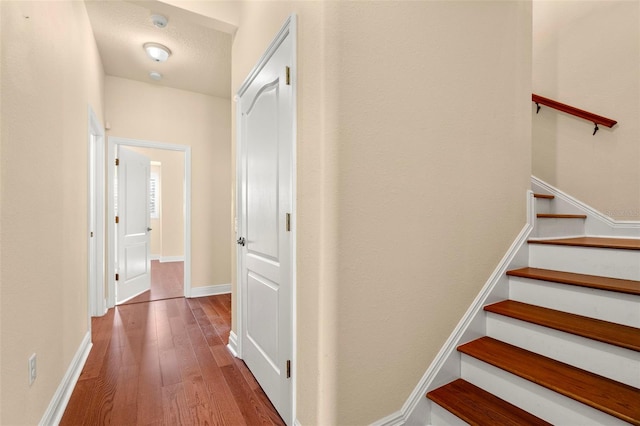 hall with hardwood / wood-style floors and a textured ceiling