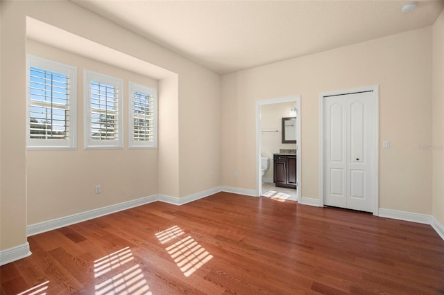 562 Rivercrest Ln, Tarpon Springs, FL 34689 - unfurnished bedroom featuring wood finished floors, baseboards, and ensuite bathroom