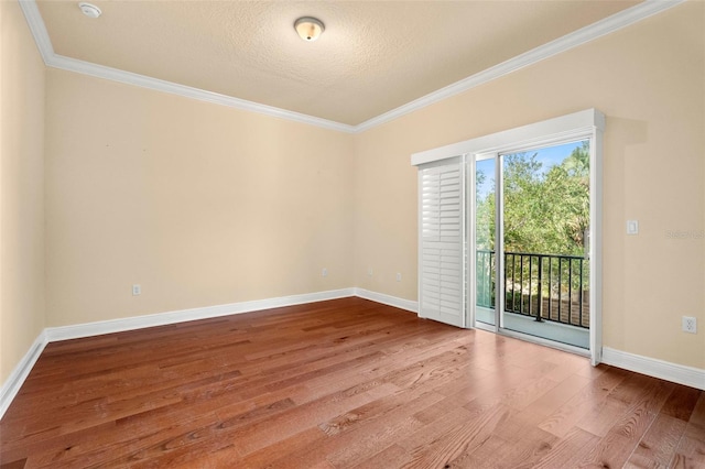 spare room with wood-type flooring, a textured ceiling, and crown molding