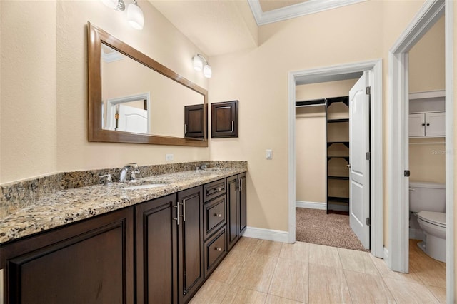 bathroom with tile patterned floors, vanity, toilet, and crown molding