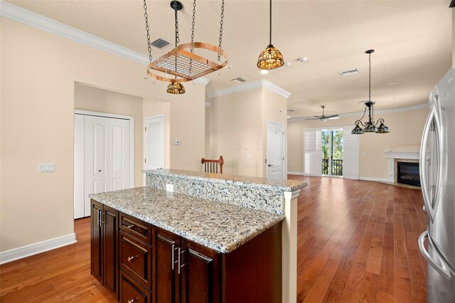 kitchen with stainless steel fridge, decorative light fixtures, light hardwood / wood-style floors, and ceiling fan