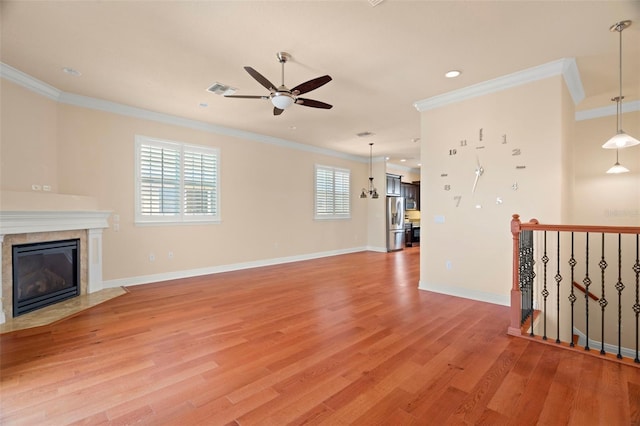 unfurnished living room featuring ceiling fan, light wood-type flooring, and crown molding