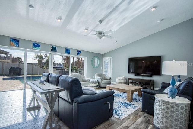 living room with hardwood / wood-style flooring, vaulted ceiling, and ceiling fan