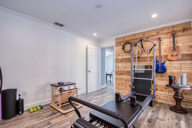 workout room with wooden walls and hardwood / wood-style floors