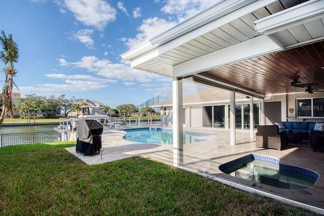 view of pool featuring a water view, a jacuzzi, ceiling fan, a yard, and a patio area