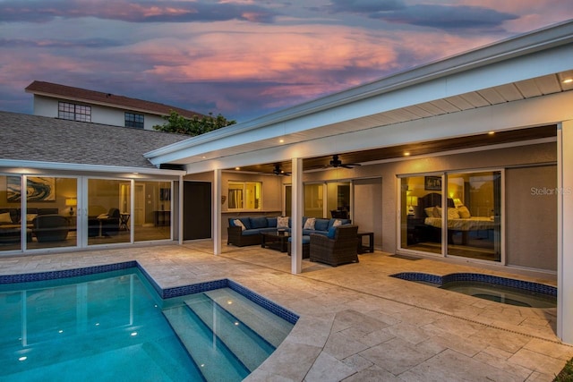 pool at dusk with a patio area, an in ground hot tub, ceiling fan, and an outdoor hangout area