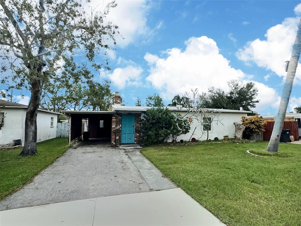 ranch-style house with a front yard and a carport