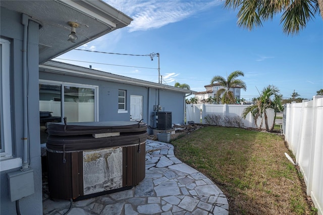 view of yard with central AC and a hot tub