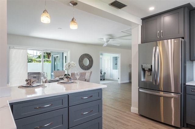 kitchen with stainless steel fridge with ice dispenser, light hardwood / wood-style flooring, ceiling fan, and decorative light fixtures