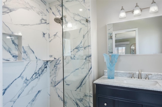 bathroom with vanity, ceiling fan, and a tile shower