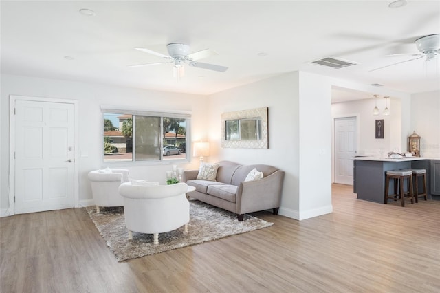 living room with ceiling fan and light hardwood / wood-style flooring