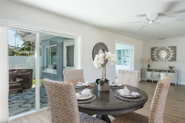 dining space with wood-type flooring and ceiling fan