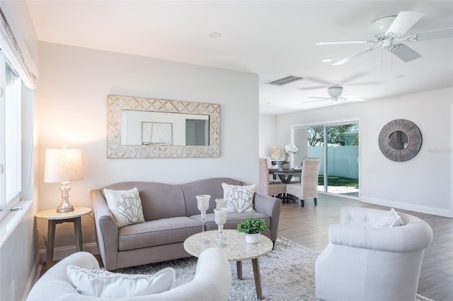 living room with ceiling fan and dark wood-type flooring