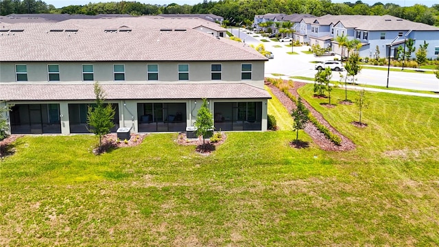 rear view of property with a sunroom and a lawn