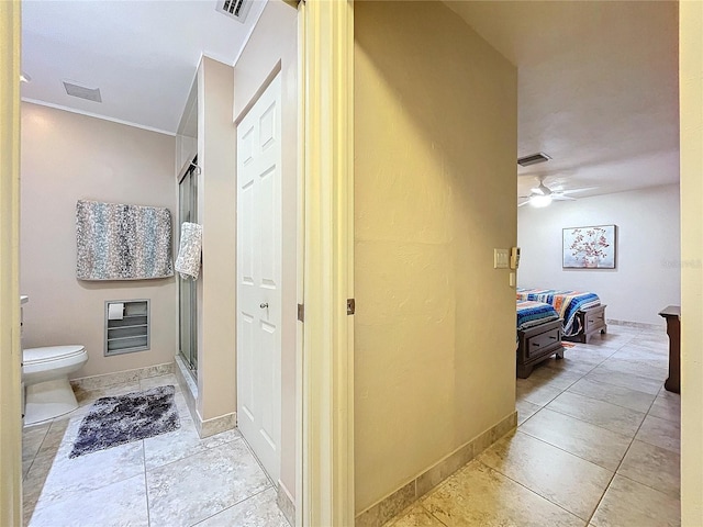 bathroom with tile patterned floors, ceiling fan, a shower with shower door, and toilet