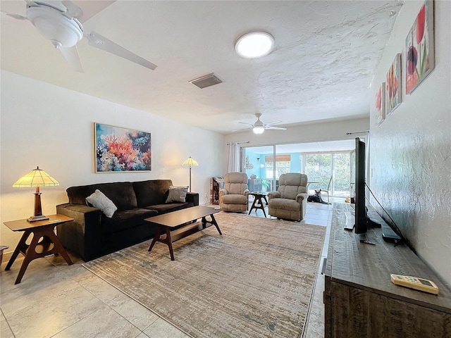 tiled living room featuring a textured ceiling and ceiling fan