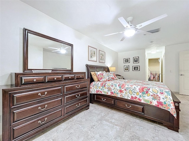 bedroom with a walk in closet, a closet, and ceiling fan