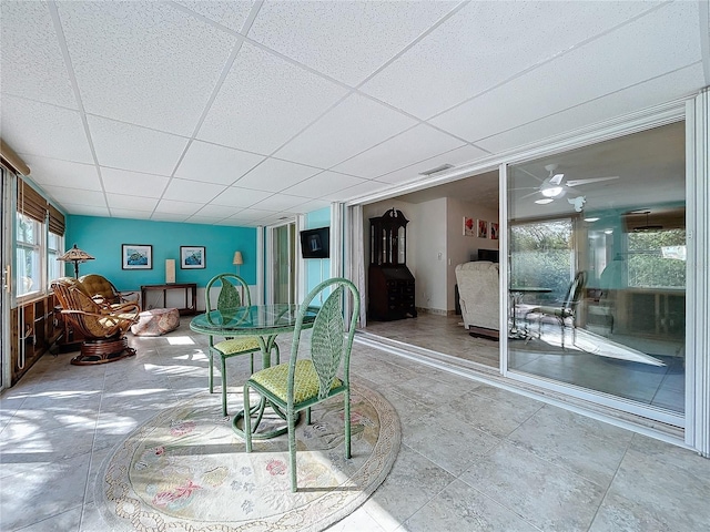 dining space featuring a drop ceiling and ceiling fan