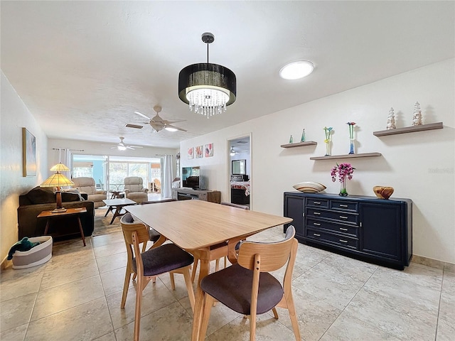 dining space with ceiling fan with notable chandelier and light tile patterned floors