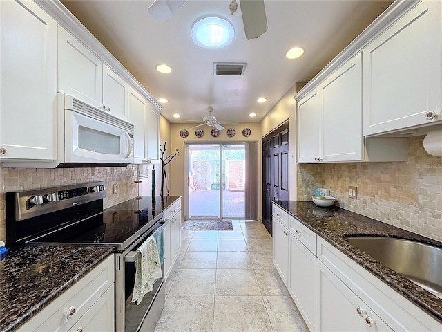 kitchen featuring white cabinets, decorative backsplash, stainless steel electric stove, and dark stone counters