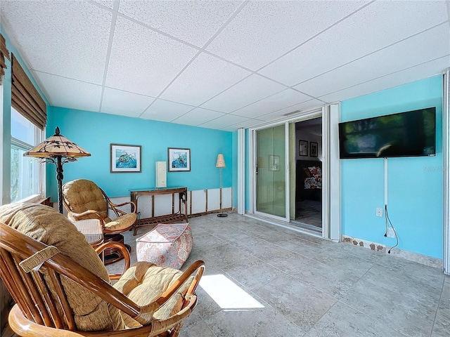 living area featuring a drop ceiling