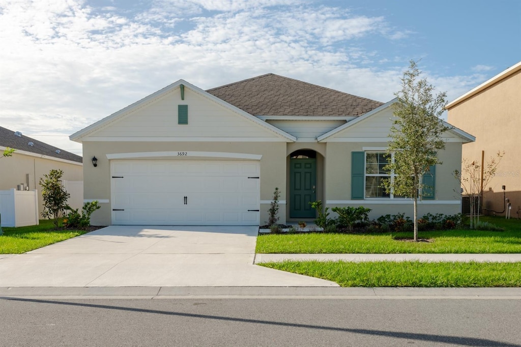 ranch-style house featuring a front yard and a garage