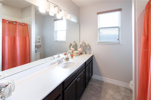 bathroom with walk in shower, vanity, toilet, and plenty of natural light