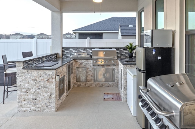 view of patio with an outdoor kitchen, an outdoor bar, and grilling area