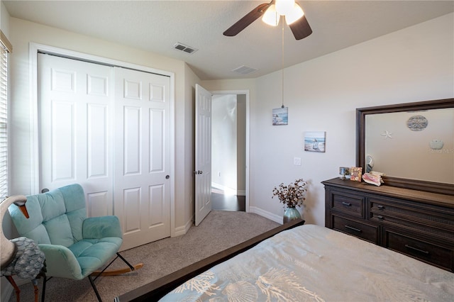 carpeted bedroom with ceiling fan, a textured ceiling, and a closet