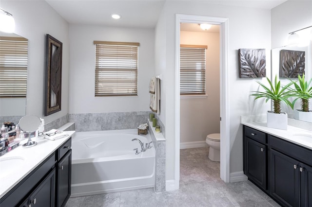 bathroom with tile patterned floors, vanity, toilet, and a bathing tub