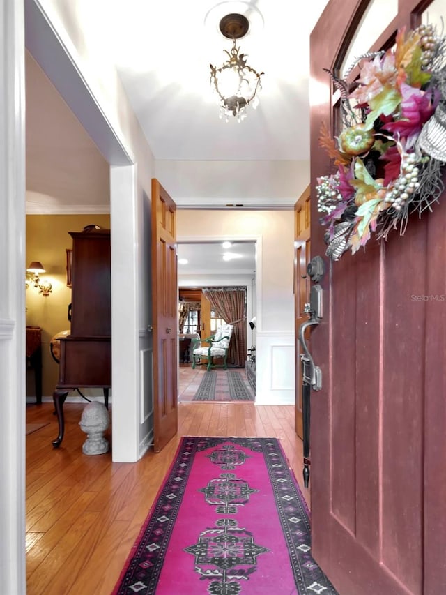 foyer with light hardwood / wood-style flooring and ornamental molding