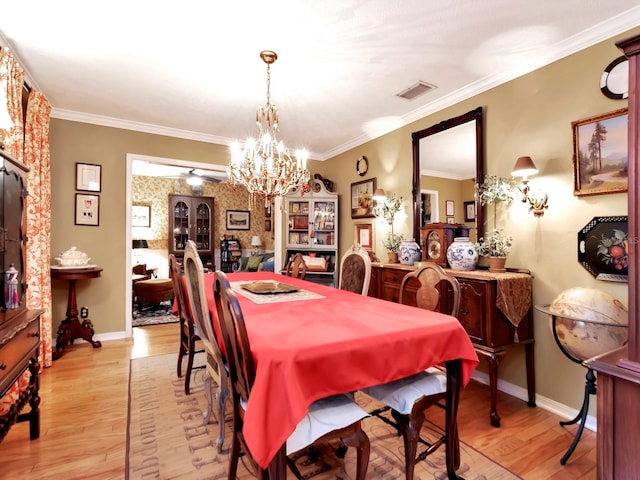 dining room featuring ceiling fan with notable chandelier, light hardwood / wood-style floors, and crown molding