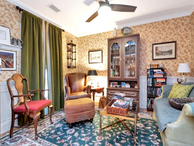 living area featuring ceiling fan and ornamental molding