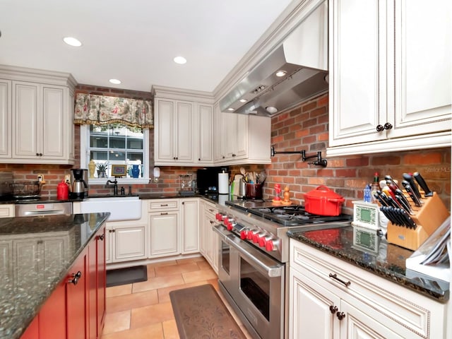 kitchen with wall chimney exhaust hood, double oven range, sink, and tasteful backsplash