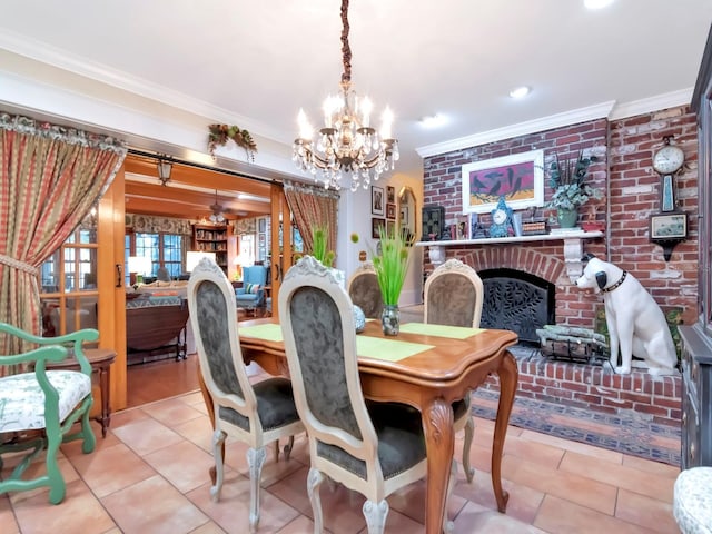 dining area featuring a brick fireplace, ornamental molding, light tile patterned floors, and a chandelier