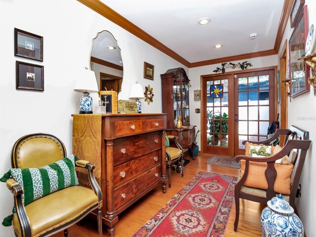 sitting room featuring light hardwood / wood-style floors, crown molding, and french doors