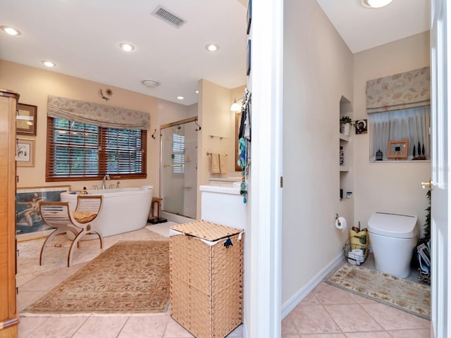 bathroom featuring tile patterned flooring, separate shower and tub, and toilet