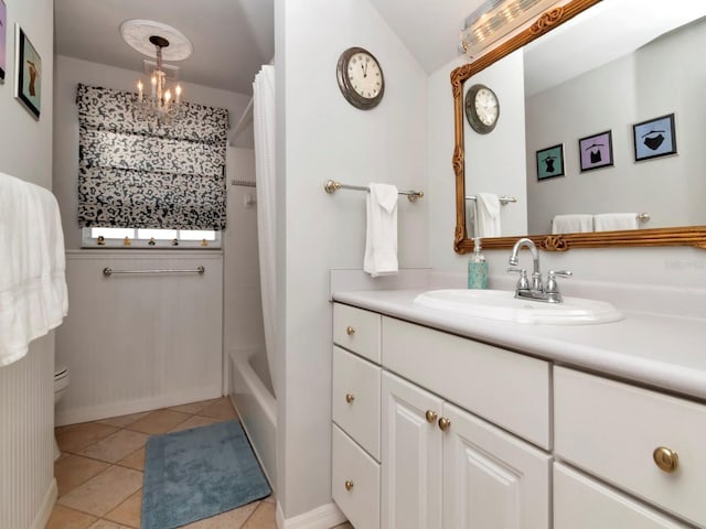 bathroom featuring tile patterned flooring, vanity, an inviting chandelier, and shower / tub combo with curtain