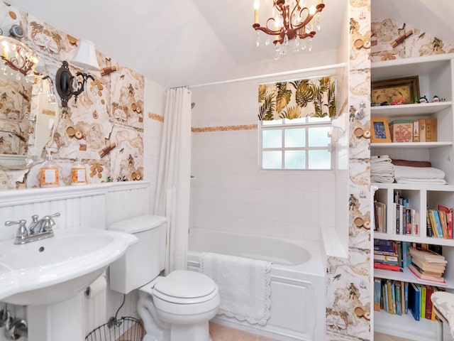 full bathroom featuring shower / bath combination with curtain, sink, vaulted ceiling, toilet, and a chandelier