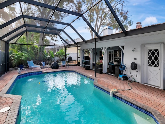 view of swimming pool featuring pool water feature, a patio, and a lanai