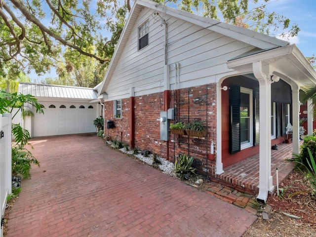 view of side of home with a porch and a garage