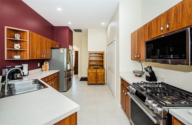 kitchen with sink, light tile patterned floors, and stainless steel appliances