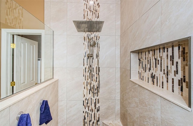 bathroom featuring a tile shower and tile walls