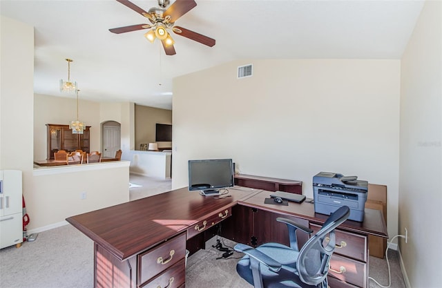 carpeted office space featuring ceiling fan with notable chandelier and vaulted ceiling