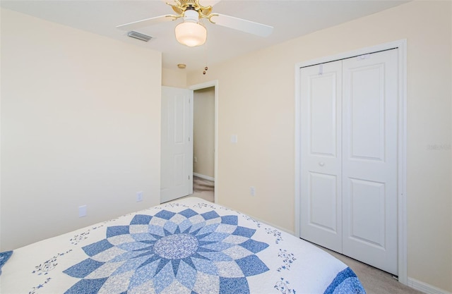 carpeted bedroom featuring ceiling fan and a closet