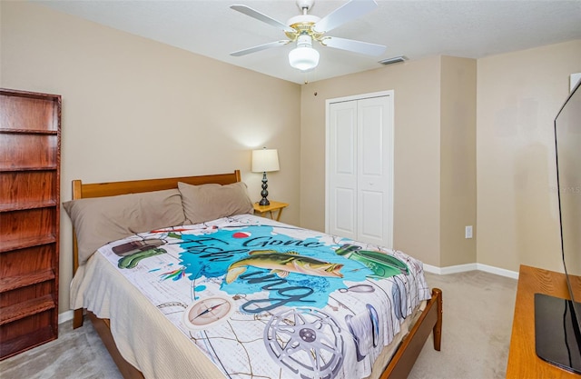 bedroom featuring ceiling fan, a closet, and light colored carpet